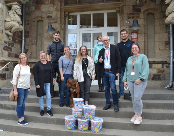 100.000 Euro für den Aufbau der Kindertagesstätte St..Hildegard. Mit dieser sehr guten Nachricht waren Mareike Schmid (Mitte) von fischer und ihr Team (im Hintergrund) nach Bad Neuenahr-Ahrweiler gekommen. Bei ihr und Jessica Willius (links neben ihr), die den Kontakt hergestellt hatte, bedankten sich (von links) Carina Kacavenda und Margot Sonntag sowie (von rechts) Louisa Hansen, Assistenz der Caritas-Geschäftsführung, und Richard Stahl.