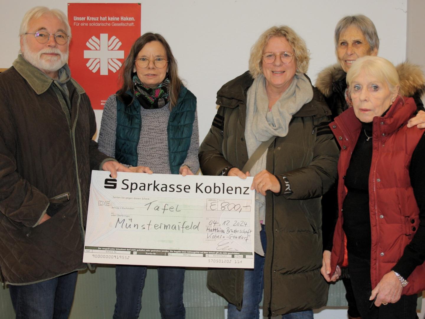 (v.l.n.r.) Brudermeister Harry Schneider, Irene Franke, Gaby Guckenbiehl und Barbara Böhlandt (Tafel Münstermaifeld), im Hintergrund Heidi Mathe (St. Matthiasbruderschaft)